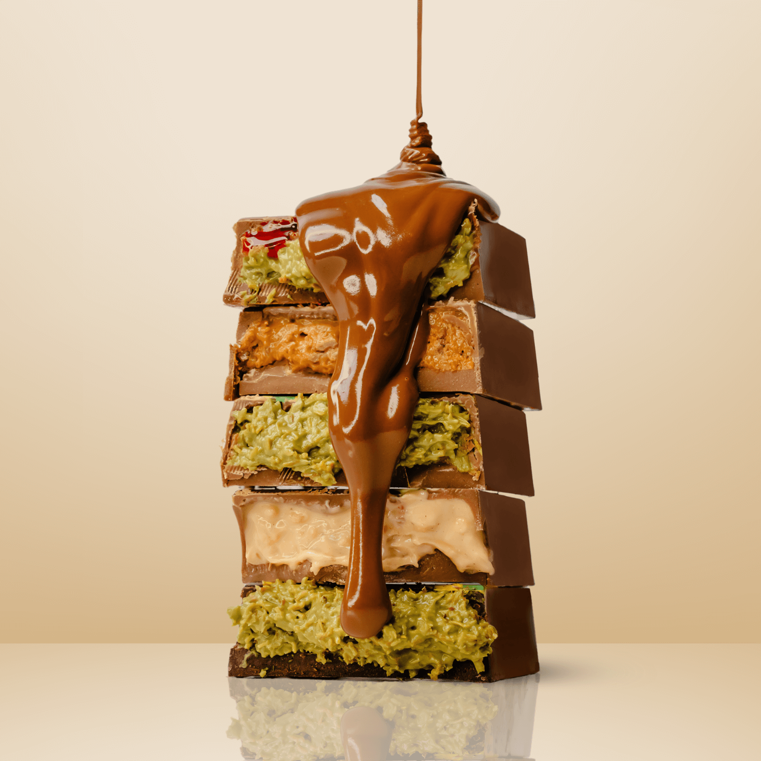 Stacked halves of four Dubai-inspired chocolate bars with melted chocolate dripping over them